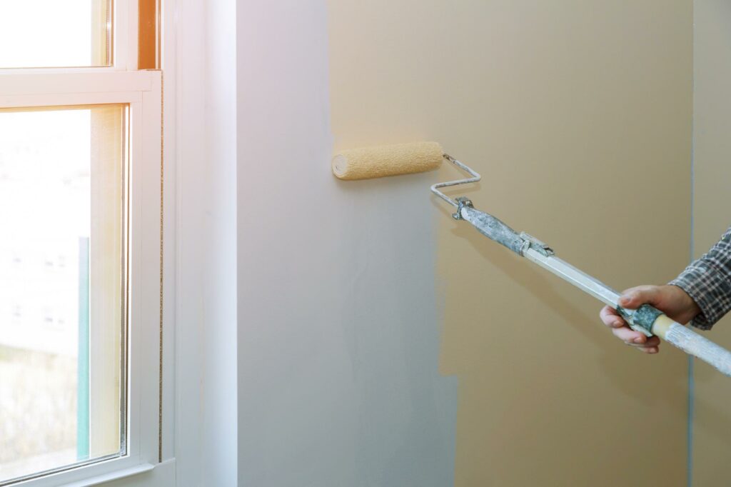Especialista pintando pared sin gotelé con un rodillo