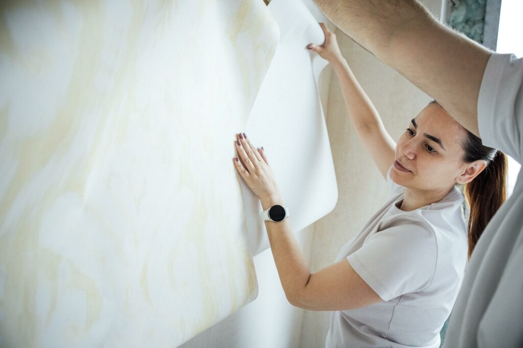 Especialistas aplicando el papel pintado adhesivo